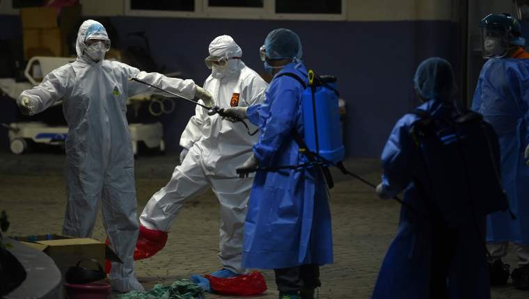 Doctores desinfectando sus trajes de bioseguridad / FOTO: Prensa Libre