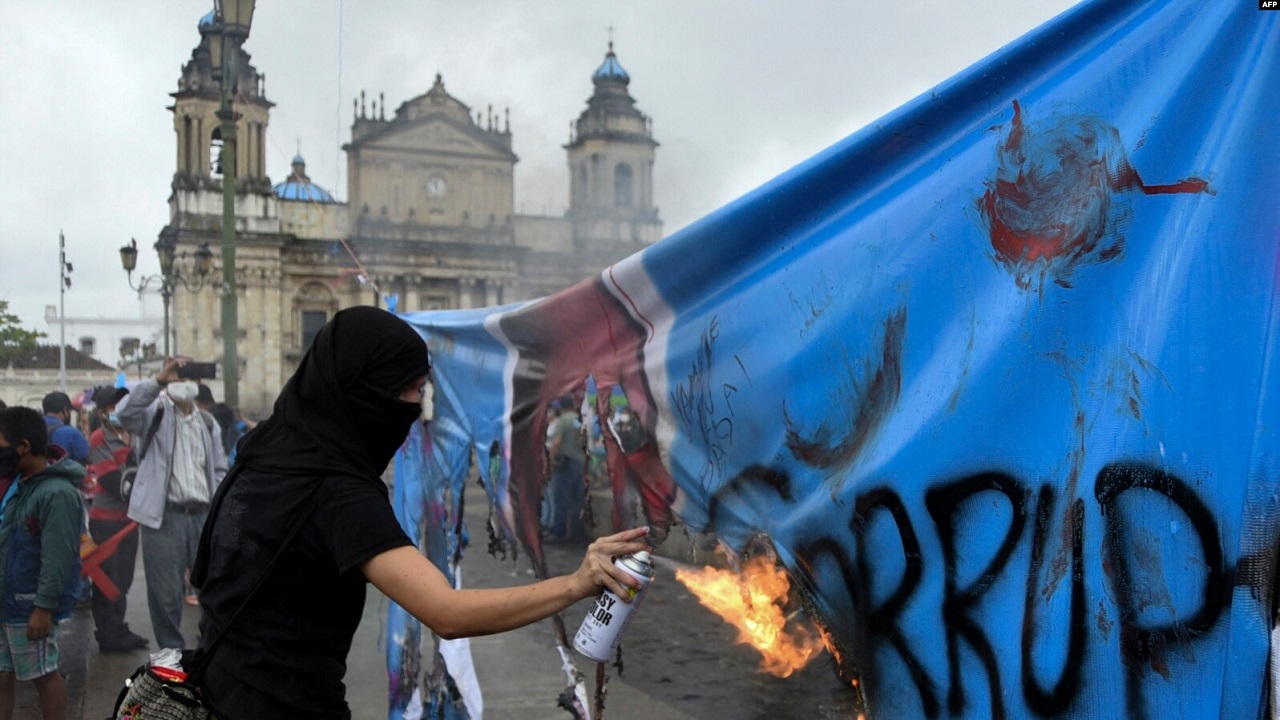 Un manifestante quema una pancarta con una fotografía de la Fiscal General de Guatemala, Consuelo Porras