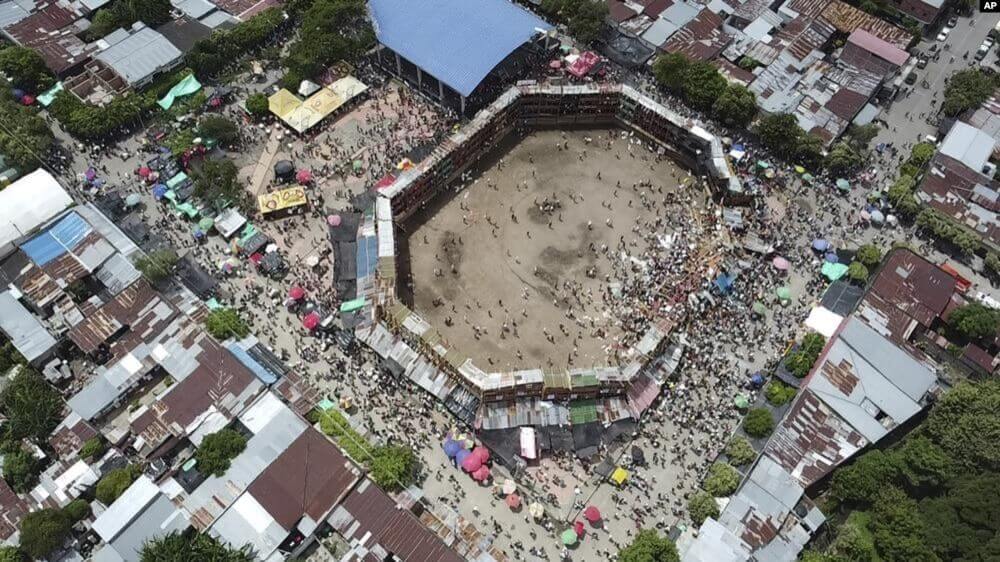 Espectadores se aglomeran cerca de donde se derrumbaron varios palcos armados en forma improvisada y con gente en ellos durante una corrida de toros en la ciudad de El Espinal, departamento de Tolima, en Colombia, el domingo 26 de junio de 2022. (AP Video)