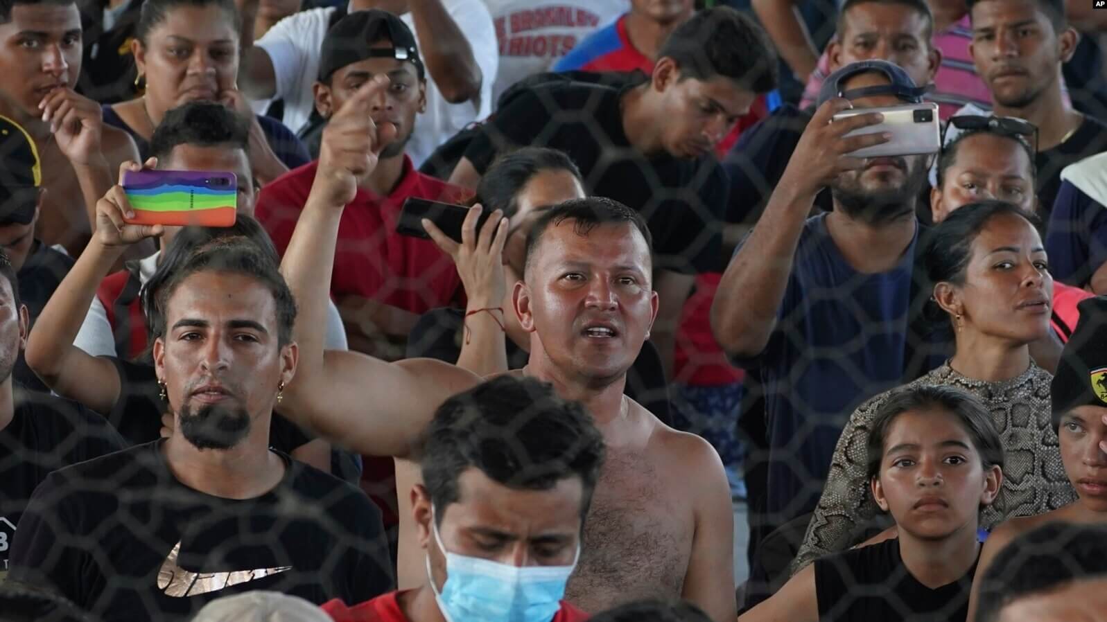 El migrante venezolano Eymar Hernández, centro, asiste a una asamblea mientras se refugia en un complejo deportivo en Huixtla, estado de Chiapas, México, el miércoles 8 de junio de 2022. (AP Foto/Marco Ugarte)