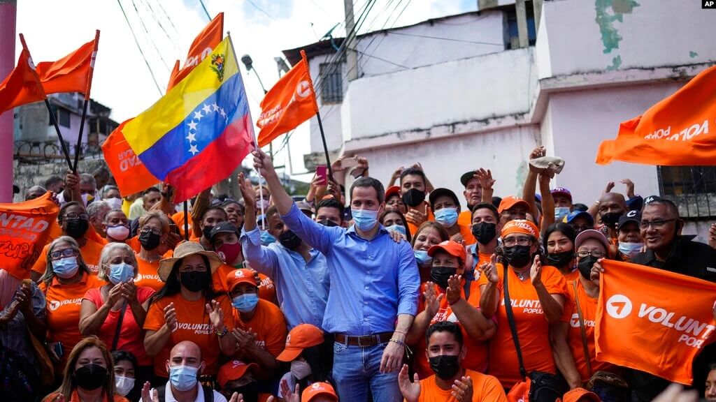 El líder de la oposición respaldada por Estados Unidos en Venezuela, Juan Guaidó, posa para una foto de grupo con residentes tras presentar su plan de unidad en Maiquetía, Venezuela, el sábado 19 de febrero de 2022.