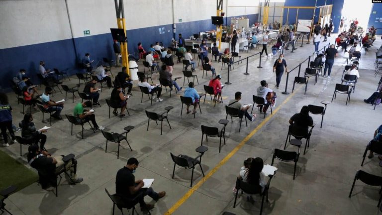 Migrantes, en su mayoría nicaragüenses, llenan papeles en un centro de migración mientras esperan una entrevista con funcionarios del gobierno para solicitar asilo en Costa Rica debido a la situación política de su país, en San José, Costa Rica, 10 de enero de 2022.