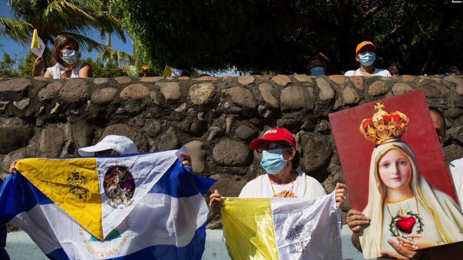 Peregrinos sostienen banderas mientras participan en un evento de la Virgen de Fátima el 13 de agosto de 2022 REUTERS/Maynor Valenzuela