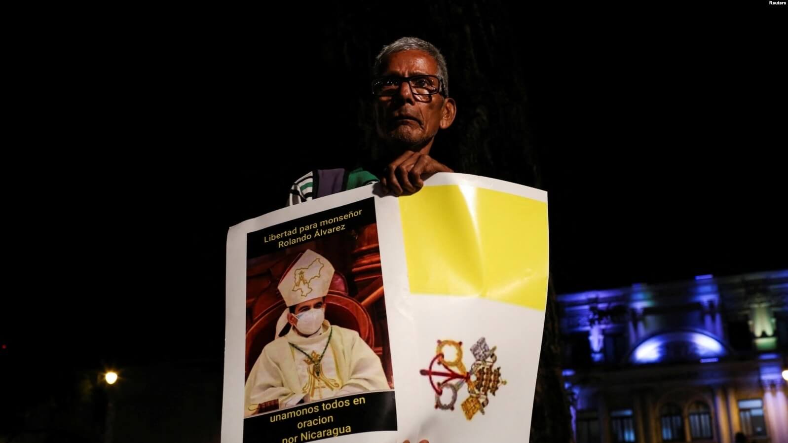 Un exiliado nicaragüense en Costa Rica sostiene un cartel con una bandera de la Ciudad del Vaticano para protestar contra la detención de Rolando Álvarez en Costa Rica. REUTERS/Mayela López