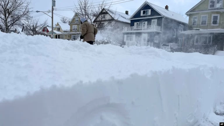 La tormenta invernal que azota a partes de Estados Unidos, como la ciudad de Nueva York, podría extenderse, de acuerdo con los pronósticos. Martin Haslinger limpia la nieve del frente de su casa el domingo 25 de diciembre de 2022 en Buffalo, N.Y.
