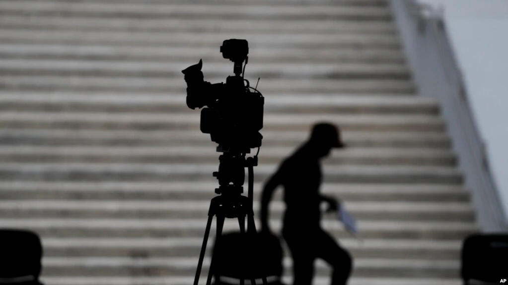 ARCHIVO - Un hombre cuenta los pasos entre sillas mientras se prepara para un evento de prensa con distanciamiento social con el presidente mexicano Andrés Manuel López Obrador, en la comuna de Coyoacán de la Ciudad de México, en abril de 2020.