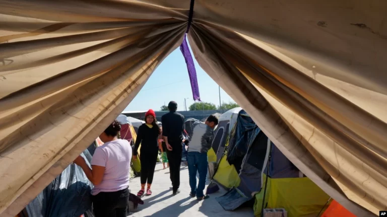 Migrantes caminan junto a sus tiendas de campaña en el refugio Senda de Vida 2 en Reynosa, México, el 15 de diciembre de 2022.
