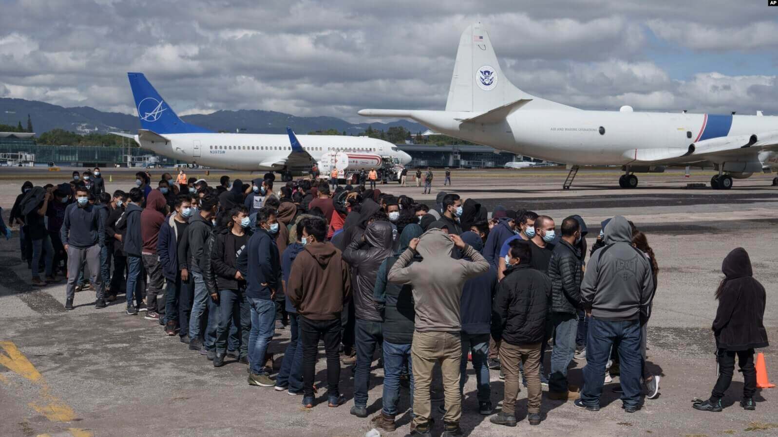 Migrantes guatemaltecos deportados desde Texas esperan en la pista del Aeropuerto Internacional La Aurora de Ciudad de Guatemala el 8 de diciembre de 2021.