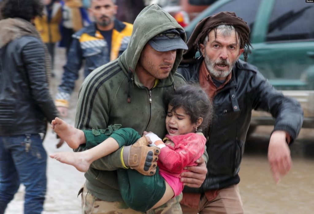 Un hombre carga a una niña en el poblad sirio de Jandaris después de un terremoto de magnitud 7,8 que azotó esa comunidad el 6 de febrero de 2023.