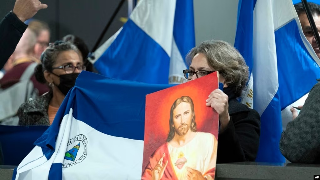 Partidarios de los presos políticos nicaragüenses cantan en el Aeropuerto Internacional Washington Dulles, en Chantilly, Virginia, el jueves 9 de febrero de 2023. (Foto AP/José Luis Magaña)