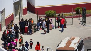 Migrantes de México y Centroamérica que buscan asilo caminan cerca del cruce fronterizo del Puerto de Entrada de San Ysidro con EEUU, en Tijuana, México, el 5 de mayo de 2022.