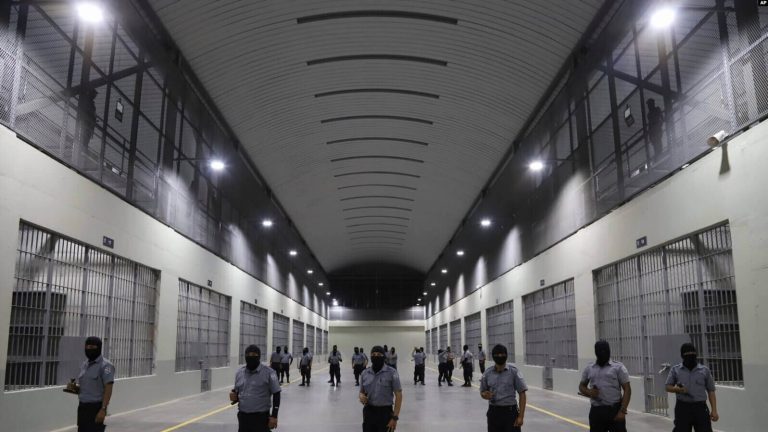 Guardias civiles de la Dirección General de Prisiones se colocan afuera de las celdas en el Centro de Confinamiento del Terrorismo durante una gira de medios en Tecoluca, El Salvador, el jueves 2 de febrero de 2023.