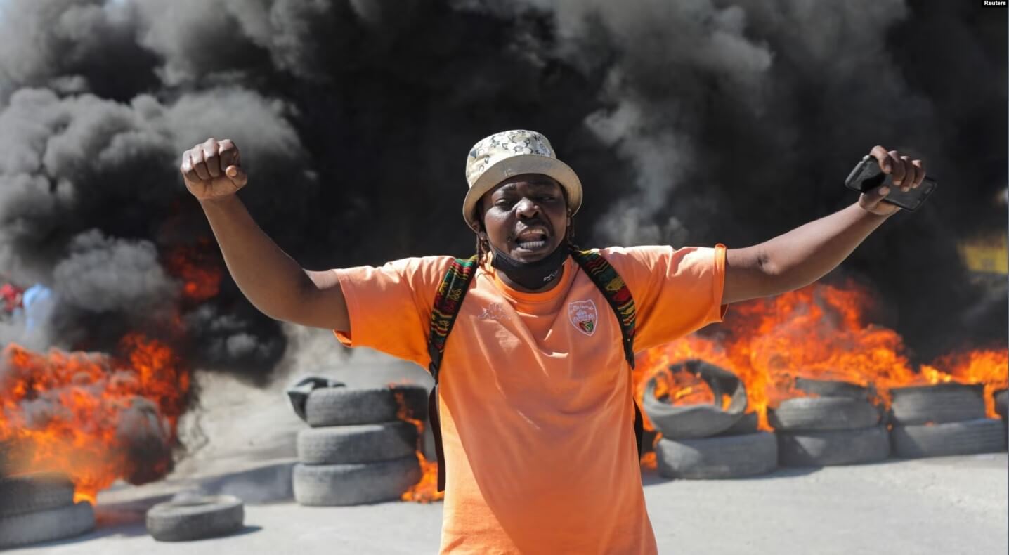 Un manifestante grita frente a una barricada en llamas durante protestas por recientes asesinatos de agentes de policía por pandillas armadas en Puerto Príncipe, Haití, el 26 de enero de 2023.