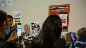 Las personas cargan sus dispositivos y hablan con familiares en un almacén administrado por el grupo sin fines de lucro Mission: Border Hope, en Eagle Pass, Texas, el 23 de mayo de 2022.