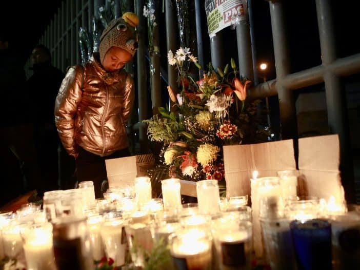 una niña enciende velas en memoria de 38 migrantes fallecidos en incendio en albergue de mexico