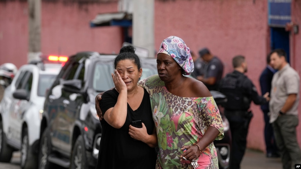 Silvia Palmieri (izquierda), quien es madre de una maestra que sobrevivió a un ataque a puñaladas en la escuela Thomazia Montorosale es consolada por una amiga el lunes 27 de marzo de 2023 en Sao Paulo, Brasil.
