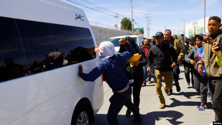 Migrantes protestan contra la política migratoria del gobierno mexicano durante la visita del presidente mexicano, Andrés Manuel López Obrador, a Ciudad Juárez.