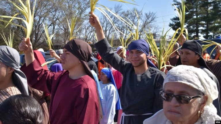 Inmigrantes latinoamericanos de diferentes edades participan en procesión del Domingo de Ramos el 2 de abril de 2023 en las calles aledañas a la iglesia de San Antonio de Padua. en Falls Church, Virginia. [Foto: Tomás Guevara, VOA]