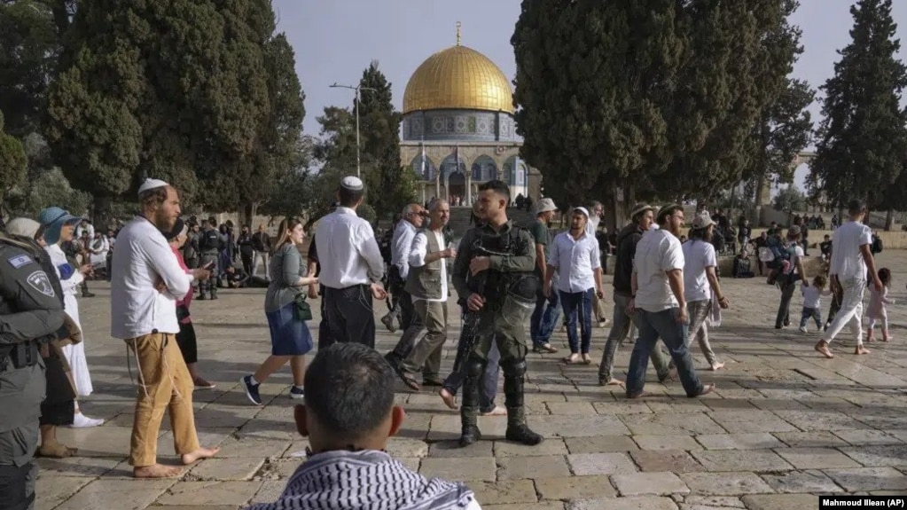 Policías israelíes escoltan a visitantes judíos en que celebran la Pascua judía en el complejo de la Mezquita de Al Aqsa, conocido por los musulmanes como Noble Santuario y por los judíos como Monte del Templo, en el casco antiguo de Jerusalén, el 9 de abril de 2023.