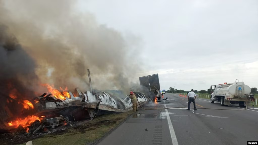 Restos humeantes de un accidente entre un camión y una furgoneta ocurrido en una carretera del estado mexicano de Tamaulipas el 14 de mayo de 2023.