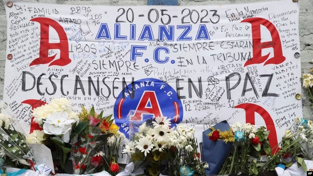 Ofrendas florares y condolencias rinden tributo a los aficionados que murieron en una estampida en el estadio Cuscatlán de San Salvador, El Salvador, el lunes 22 de mayo de 2023.