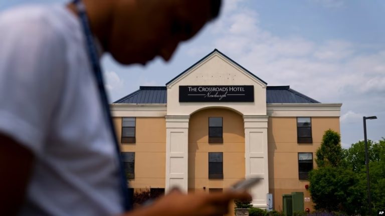 Mohamed, de 19 años, que huyó de la persecución política en Mauritania, posa para una foto ocultando su rostro para proteger su identidad, en el exterior del hotel Crossroads, antes de una entrevista de trabajo, el 22 de mayo de 2023, en Newburgh, Nueva York.