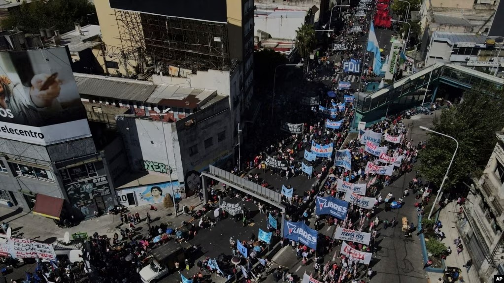 ARCHIVO - Argentinos marchan contra la pobreza y exigen más programas sociales del gobierno mientras bloquean el Puente Pueyrredon, el principal punto de entrada a Buenos Aires, el miércoles 5 de abril de 2023.
