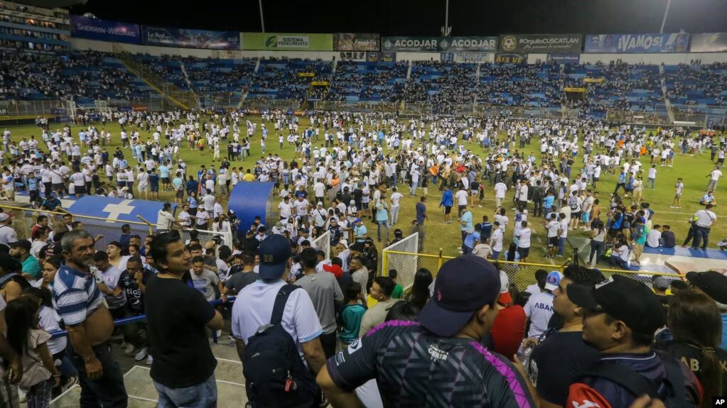 Aficionados irrumpen en el terreno del estadio Cuscatlán en San Salvador, El Salvador, para ayudar a las víctimas de una estampida que dejó 9 muertos y decenas de heridos el 20 de mayo de 2023.