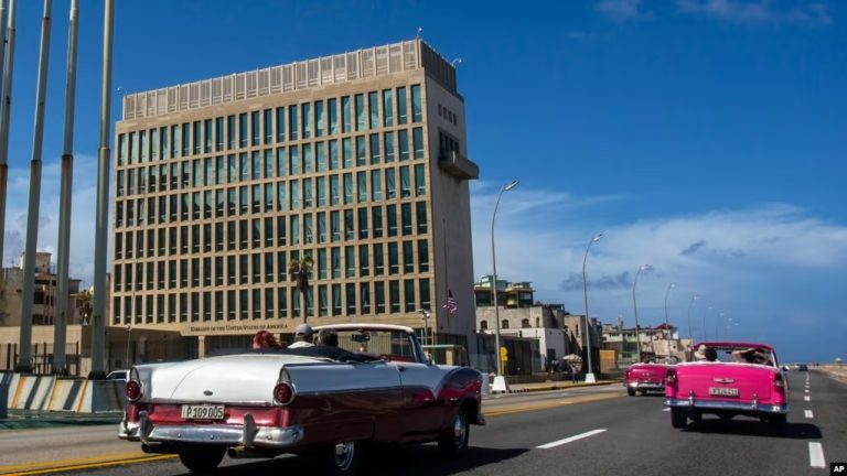 ARCHIVO - Turistas viajan en autos convertibles clásicos en el Malecón junto a la Embajada de Estados Unidos en La Habana, Cuba, el 3 de octubre de 2017.