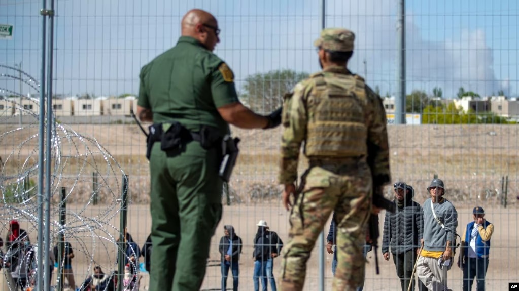 Migrantes aguardan a un costado del muro fronterizo vigilado por la Patrulla Fronteriza y la Guardia Nacional de Texas el miércoles 10 de mayo de 2023, con el fin de ingresar a El Paso, Texas. Nicaragüenses