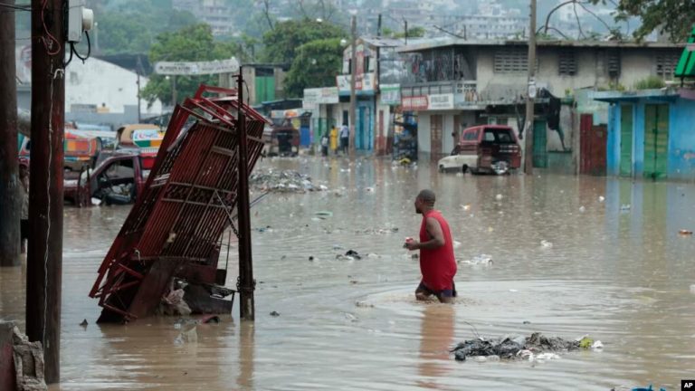 Un hombre camina por una calle inundada después de una fuerte lluvia en Puerto Príncipe, Haití, el sábado 3 de junio de 2023.