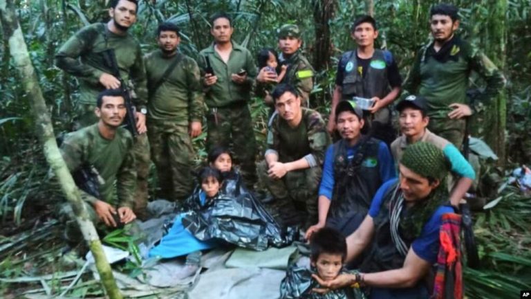 En esta foto publicada por la Oficina de Prensa de las Fuerzas Armadas de Colombia, soldados e indígenas posan para una foto con los cuatro hermanos indígenas que desaparecieron después de un accidente aéreo en la selva. (Oficina de Prensa de la Fuerza Armada de Colombia vía AP)