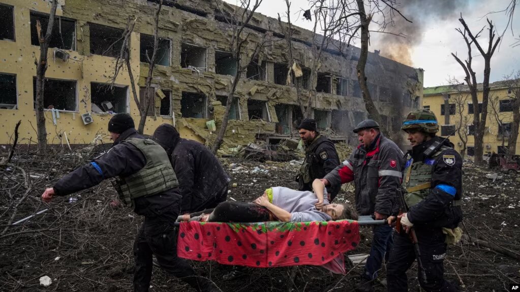 ARCHIVO - Empleados de emergencia y policías ucranianos evacuan a la mujer embarazada herida Iryna Kalinina, de 32 años, de un hospital de maternidad dañado por un ataque aéreo ruso en Mariupol, Ucrania, el 9 de marzo de 2022.