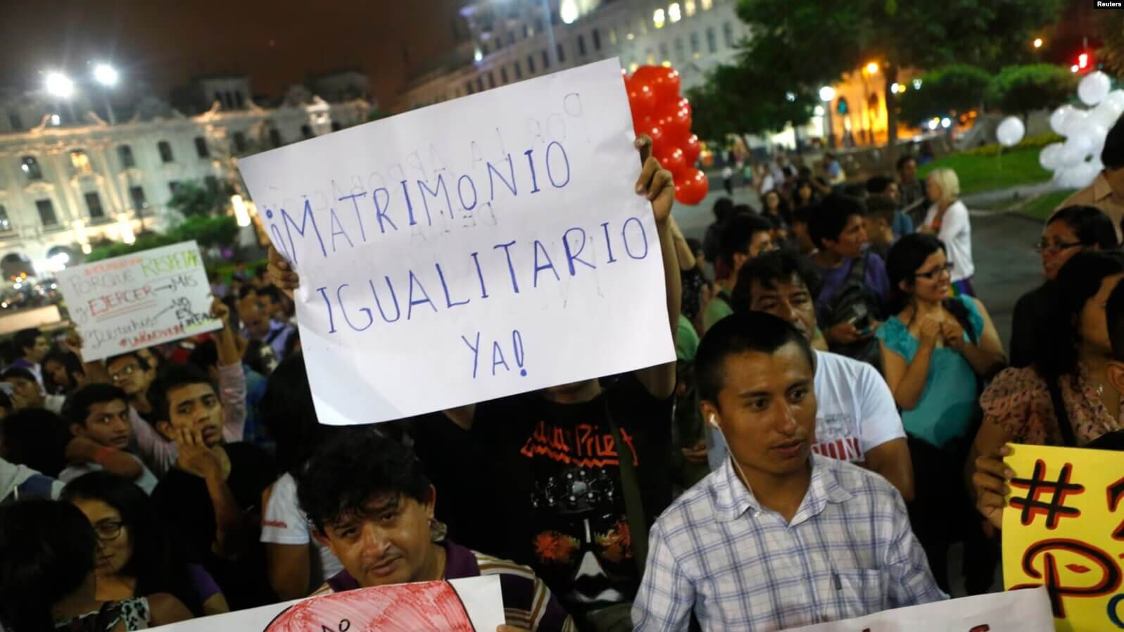 Miembros de organizaciones de homosexuales y lesbianas sostienen carteles mientras marchan en apoyo del proyecto de ley de Unión Civil en Lima, 2 de marzo de 2015.
