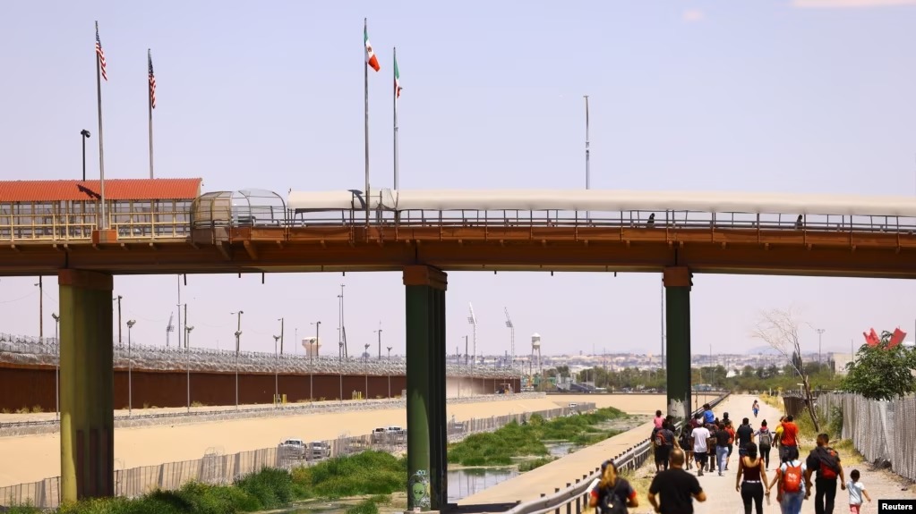 Migrantes caminan cerca del Puente Internacional Paso del Norte en Ciudad Juárez, México, el 26 de julio de 2023. Foto VOA