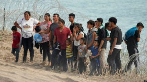 ARCHIVO: Migrantes que cruzaron el Río Grande desde México a EEUU esperan en Eagle Pass, Texas, el 31 de julio de 2023.