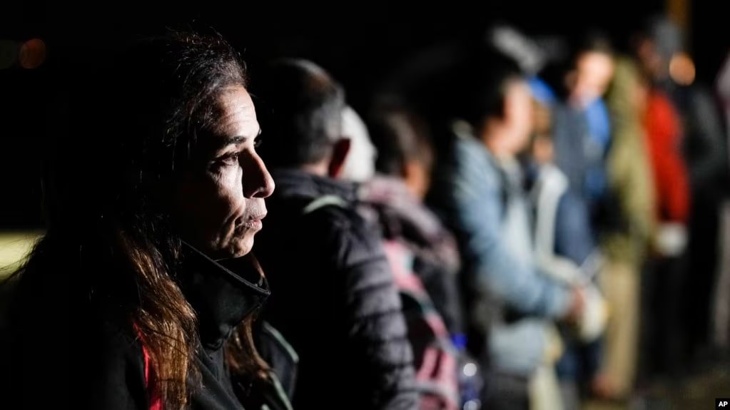 ARCHIVO - Una mujer de Cuba espera con otros migrantes para ser procesados para buscar asilo después de cruzar la frontera hacia Estados Unidos, el viernes 6 de enero de 2023, cerca de Yuma, Arizona.