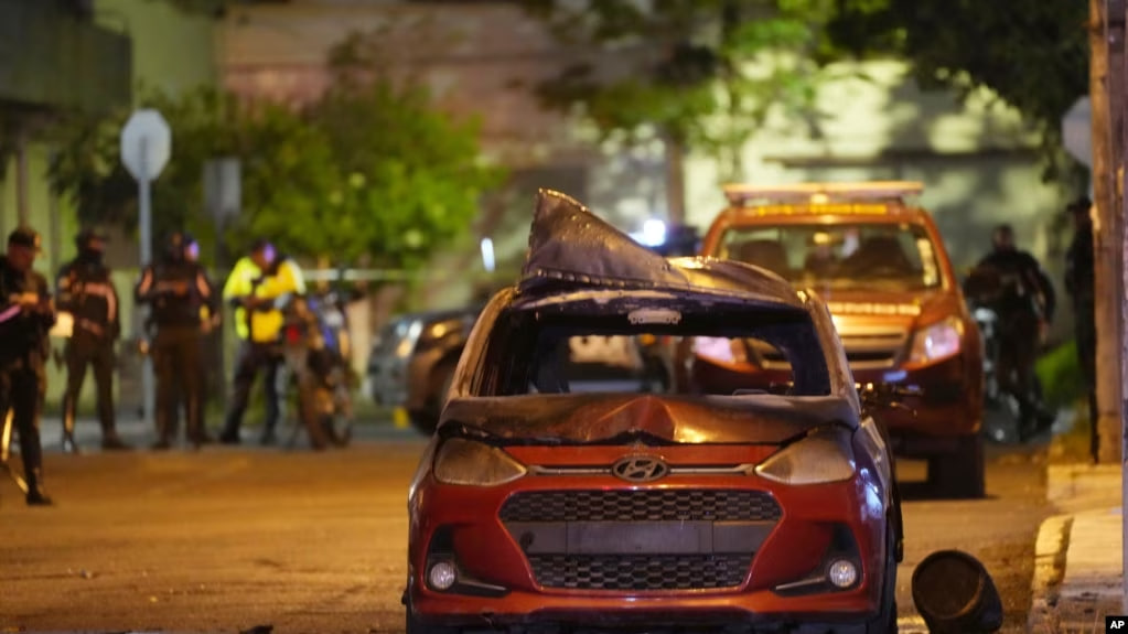 Un vehículo que explotó frente al edificio del Ministerio de la Mujer y Derechos Humanos es acordonado por las autoridades en Quito, Ecuador, la noche del 30 de agosto de 2023.