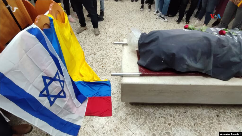 Banderas de Israel y Colombia pueden verse el 12 de octubre de 2023 frente a los restos de la colombiana Ivonne Rubio, muerta tras el ataque de Hamás al festival Nova, al comienzo de la incursión del grupo militante a territorios israelíes cercanos a la Franja de Gaza. colombiano