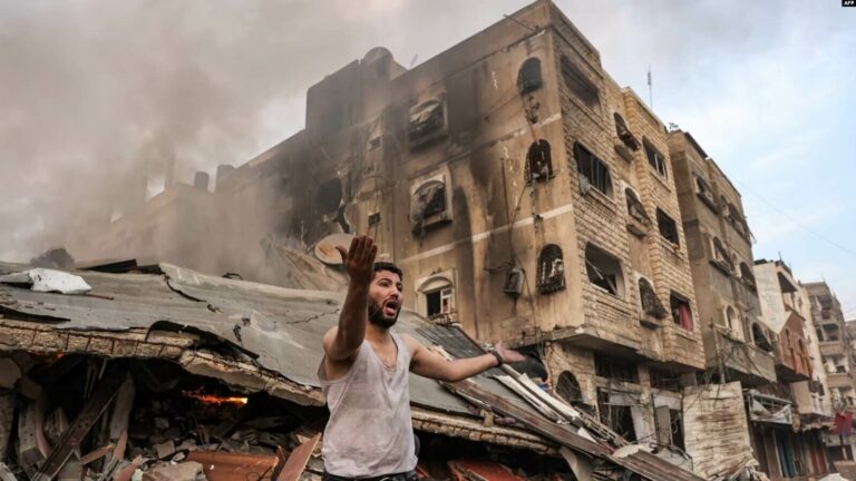 Un hombre reacciona frente a un edificio derrumbado en llamas tras el bombardeo israelí en la ciudad de Gaza el 11 de octubre de 2023.