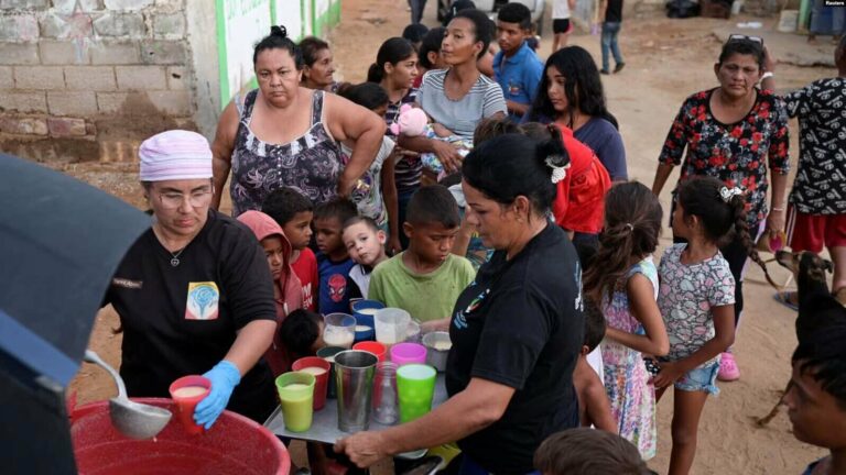 La gente recibe alimentos de Carolina Leal, directora y fundadora de la fundación Alimentando sueños, en Maracaibo, Venezuela, 12 de junio de 2024