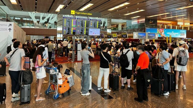 Los pasajeros formaron largas colas en el aeropuerto de Singapur debido a una importante interrupción del servicio informático en Singapur el 19 de julio de 2024. (Foto de Roslan RAHMAN / AFP)